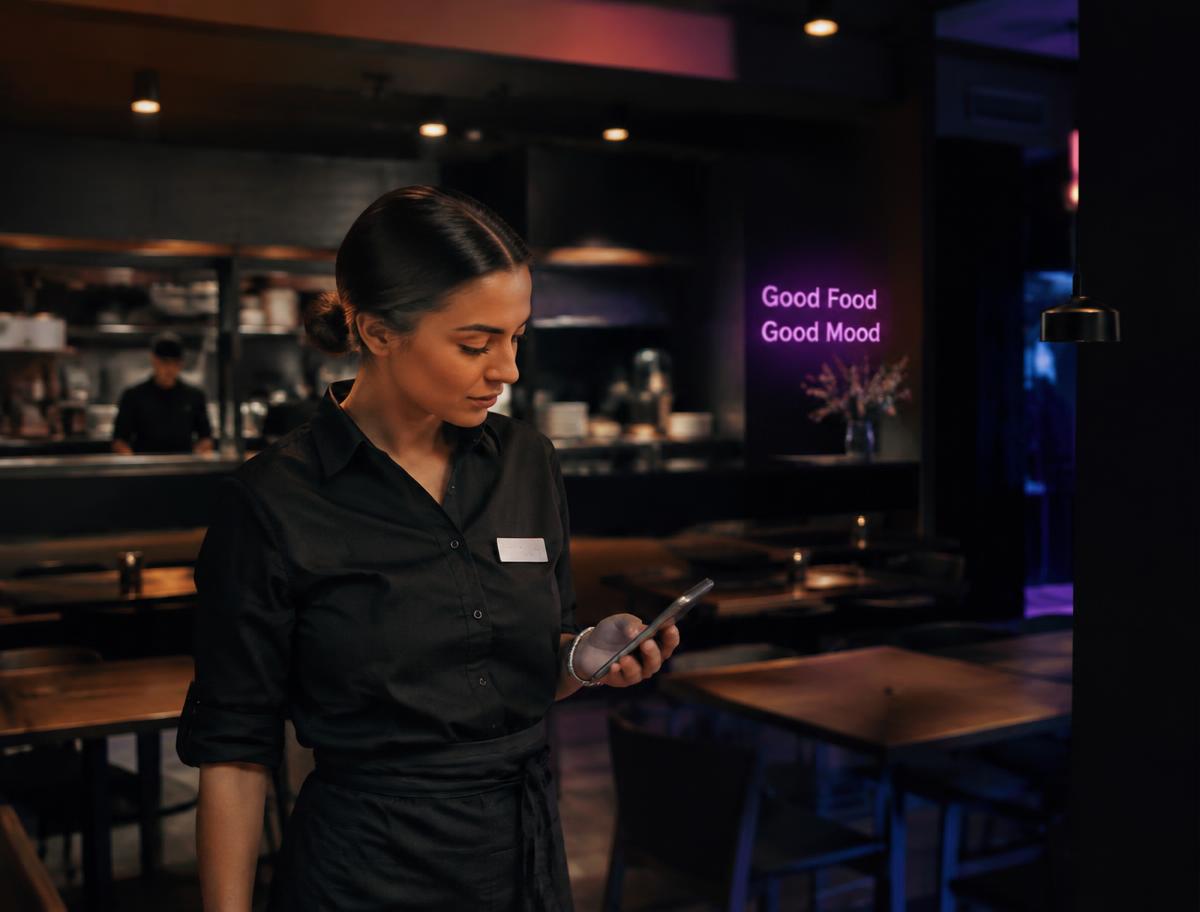 Manager consultant son smartphone dans un restaurant
